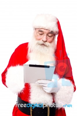 Old Aged Santa Using Touchscreen Pad Stock Photo