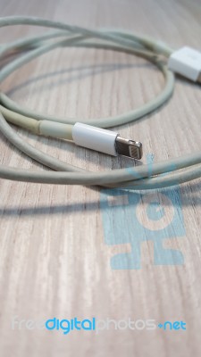 Old Smart Phone Charger Wire On Laminate Floor Stock Photo