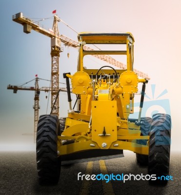 Old Yellow Motor Grader On The Road Stock Photo