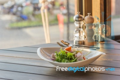 Olive Oil Pouring Into Bowl Of Salad Stock Photo