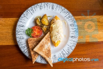 Omelet With Potato, Tomatoes Parsley And Feta Cheese And Bread In White Plate On Wooden Table Stock Photo