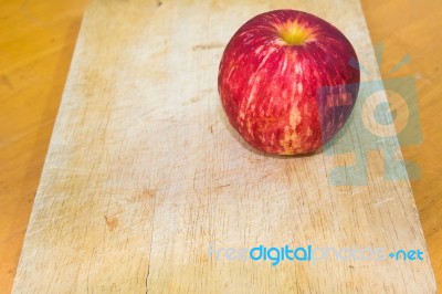 One Apple On The Chopping Block In Kitchen Stock Photo