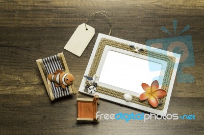 One Photo Frame With Beach Bed And Chair And Price Tag On Wooden Table Stock Photo