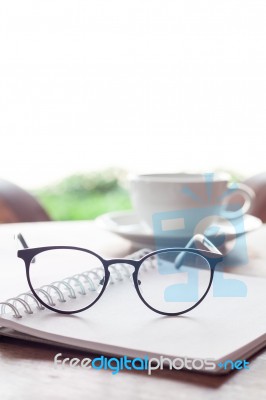 Open Blank White Notebook And Eyeglasses With Cup Of Coffee Stock Photo