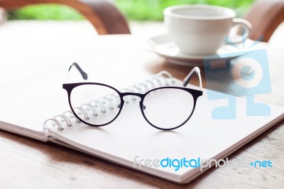 Open Blank White Notebook And Eyeglasses With Cup Of Coffee Stock Photo