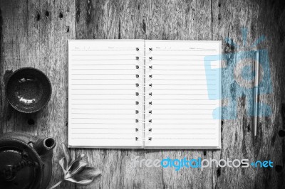 Open Notebook And Pen On Old Wooden Background, Black And White Stock Photo