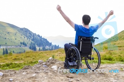 Optimistic Handicapped Man Sitting On Wheelchair Stock Photo