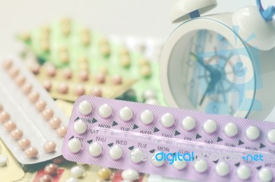 Oral Contraceptive Pills With Alarm Clock Background Stock Photo