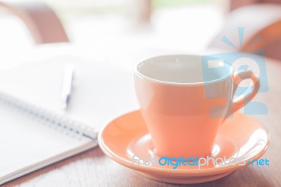 Orange Coffee Cup With Pen And Notebook Stock Photo