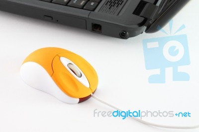 Orange Computer Mouse On Working Desktop Stock Photo