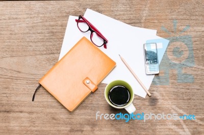 Orange Diary,blank Paper With Pencil, A Cup Of Coffee, Mobile Phone And Eye Glasses Stock Photo