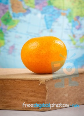 Orange On An Old Book Stock Photo