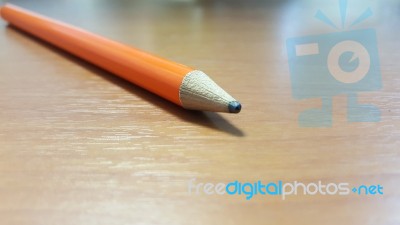 Orange Pencil On Wooden Desk Stock Photo