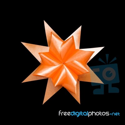 Orange Ribbon Flower Made With Folded Hands On Black Background Stock Photo