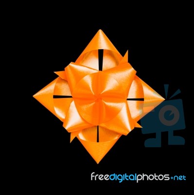 Orange Ribbon Flower Made With Folded Hands On Black Background Stock Photo