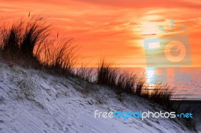 Orange Sunset With Dune And Sea Stock Photo