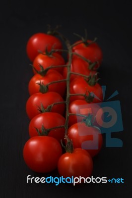 Organic Fresh Cherry Tomatoes On Black Board Background Stock Photo