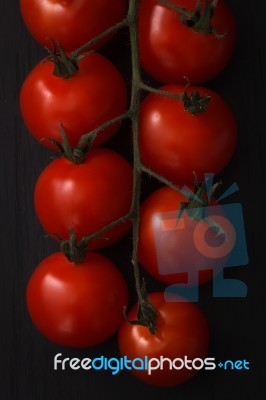 Organic Fresh Cherry Tomatoes On Black Board Background Stock Photo