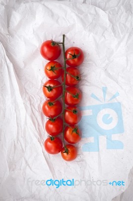 Organic Fresh Cherry Tomatoes On White Paper Background Stock Photo