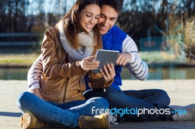 Outdoor Portrait Of Young Couple With Digital Tablet Stock Photo