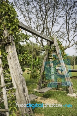 Outdoor Wooden Swing In Field Stock Photo