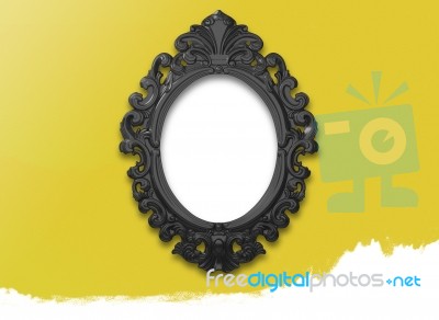 Oval Black Picture Frame With A Decorative On Yellow Wall Stock Image