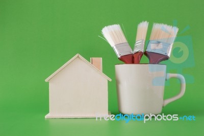 Paint Brush With Wooden House Symbol On Wooden Floor Background Stock Photo