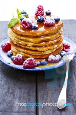 Pancakes With Honey And Berries On White Background Stock Photo