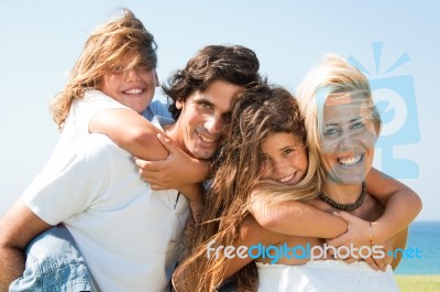 Parents Giving Piggyback Rides  Stock Photo