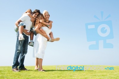 Parents Giving Piggyback Rides Stock Photo