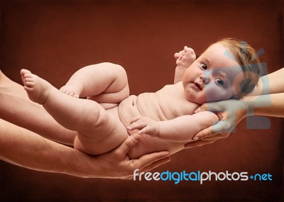 Parents Holding Baby Girl On Their Arms Stock Photo