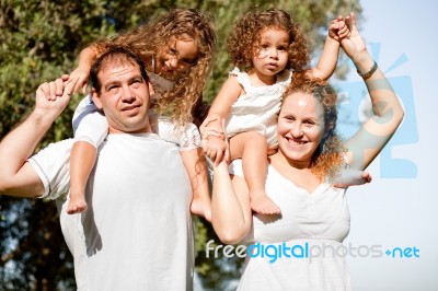 Parents Holding Children On Shoulder Stock Photo
