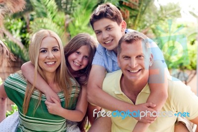 Parents Piggy Backing Kids Stock Photo