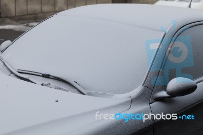 Parked Car Covered With The First Snow In Winter Stock Photo