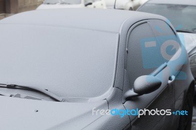 Parked Car Covered With The First Snow In Winter Stock Photo