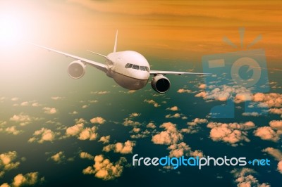 Passenger  Plane Flying Over Beautiful Light Sky For Air Traveling Theme Stock Photo