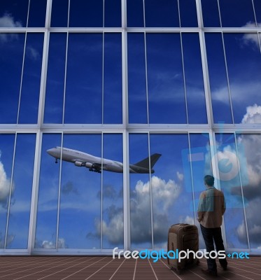 Passenger Standing With Big Suitcase In Airport And Looking To A… Stock Photo