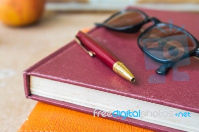 Pen And Glasses On Books Stock Photo