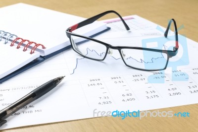 Pen, Notebook, Glasses And Financial Report Stock Photo