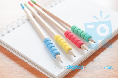 Pencils On Open Blank White Notebook On The Desk Stock Photo