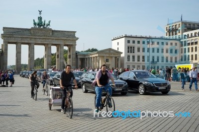 People Cycling Near The Brandenburg Gate In Berlin Stock Photo