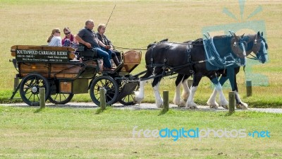 People Enjoying A Horse And Carriage Ride Through Southwold Stock Photo