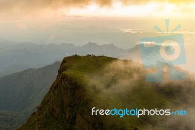 People Hiking To Top Of Mountain With Flowing Mist And Beautiful… Stock Photo