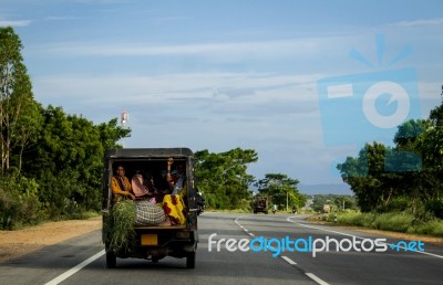 People Traveling In The Back Of A Crammed Vehicle Down A Road In… Stock Photo