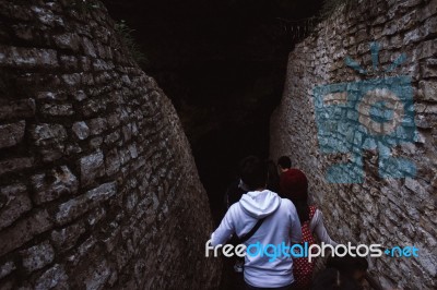 People Walking Into A Cavern Stock Photo