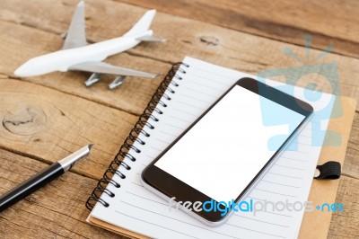 Phone Blank Screen And Airplane Model On Wood Table Stock Photo