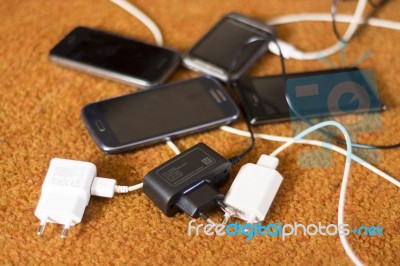 Phone Chargers On The Floor Stock Photo