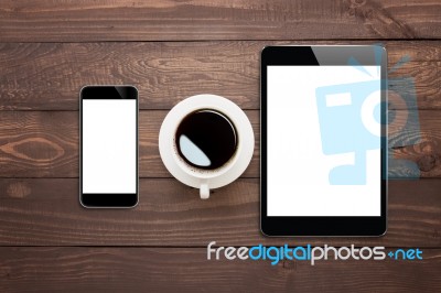 Phone Tablet And Coffee Cup On Wood Table Top View Stock Photo