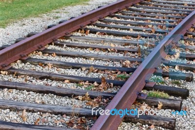 Photo Of The Rusty Railroad And Fallen Leaves Stock Photo