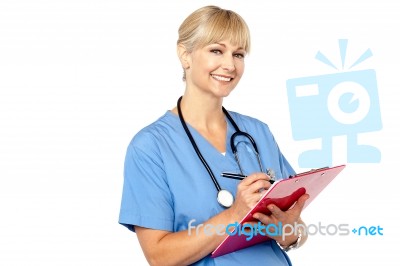 Physician With Clipboard Smiling At Camera Stock Photo